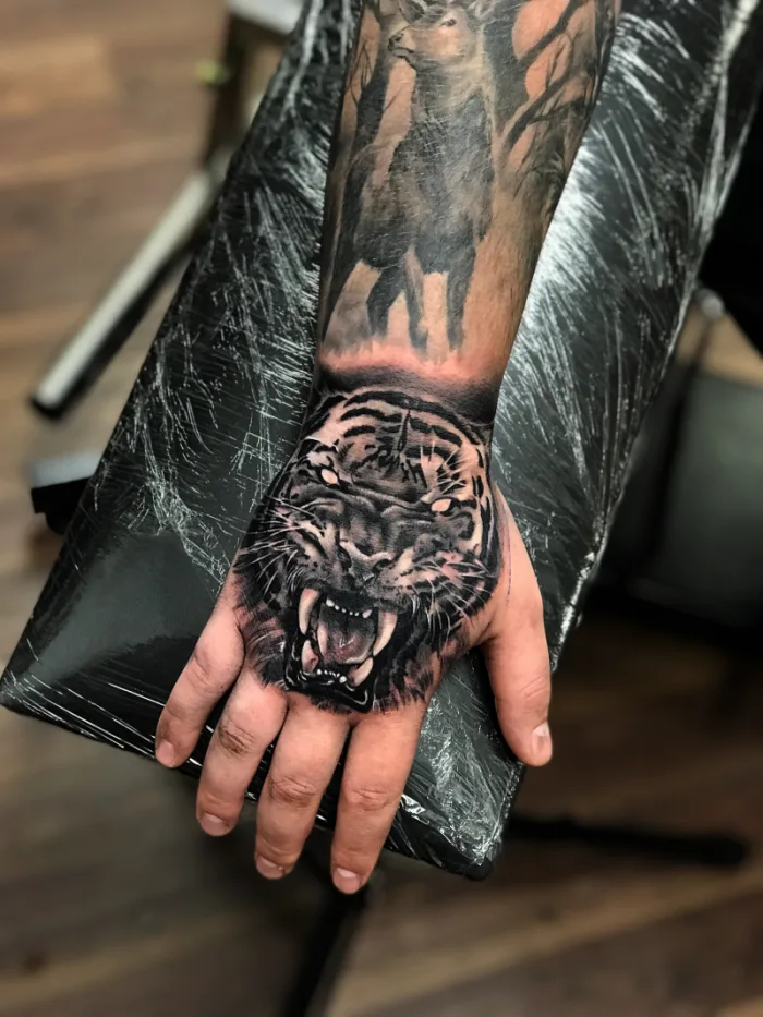Black and grey roaring tiger hand tattoo part of full sleeve by Esther, Unicorn Tattoo Art Collective, Ashford Surrey