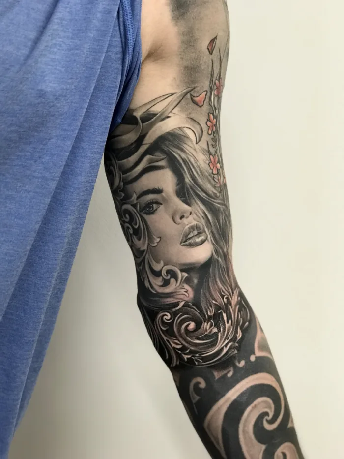 Black grey and colour female portrait with baroque scrollwork and cherry blossom full sleeve tattoo by Esther, Unicorn Tattoo Art Collective, Ashford Surrey