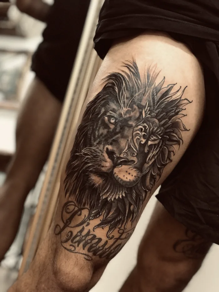 Large black and grey lion with script lettering thigh tattoo by Esther, Unicorn Tattoo Art Collective, Ashford Surrey