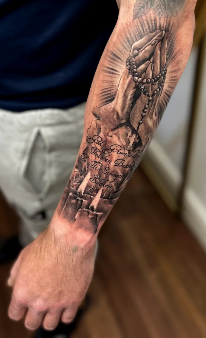 Black and grey religious praying hands rosary and cross forearm sleeve tattoo with script quote by Esther, Unicorn Tattoo Art Collective, Ashford Surrey