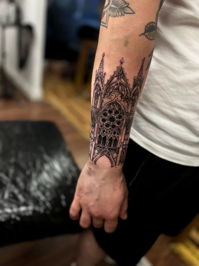 Detailed fine line gothic cathedral architecture forearm tattoo in black and grey by Esther, Unicorn Tattoo Art Collective, Ashford Surrey