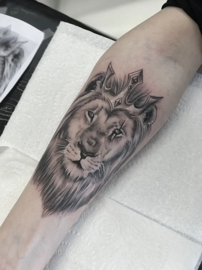 Black and grey lion with crown forearm tattoo by Esther, Unicorn Tattoo Art Collective, Ashford Surrey