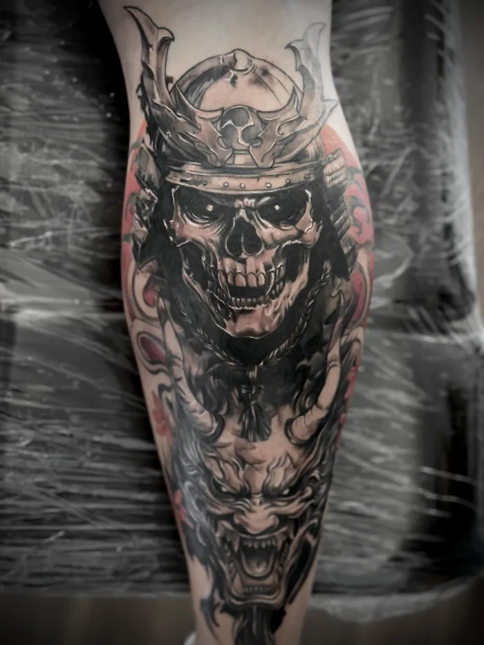 Samurai skull leg tattoo black and grey with red accents Unicorn Tattoo Art Collective Ashford Surrey