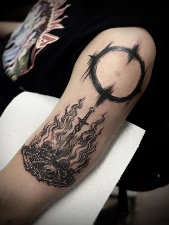 Black and grey skull and sword tattoo by Esther at Unicorn Tattoo Art Collective in Ashford, Surrey