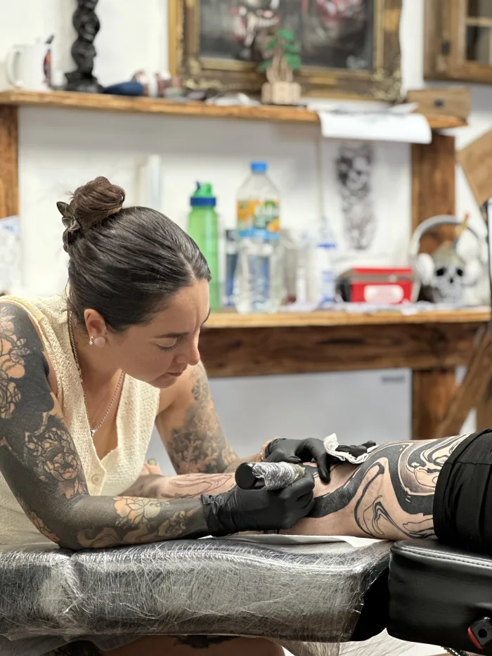 Esther tattooing a large abstract blackwork leg piece at Unicorn Tattoo in Ashford, Surrey