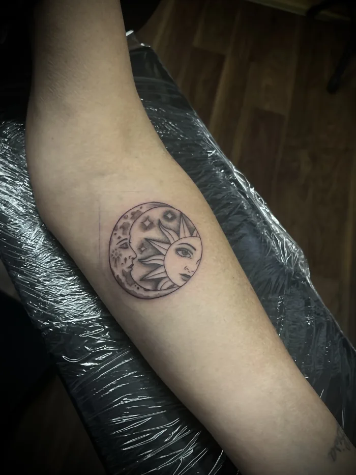 Fine line sun and moon tattoo on the forearm by Esther in Ashford, Surrey