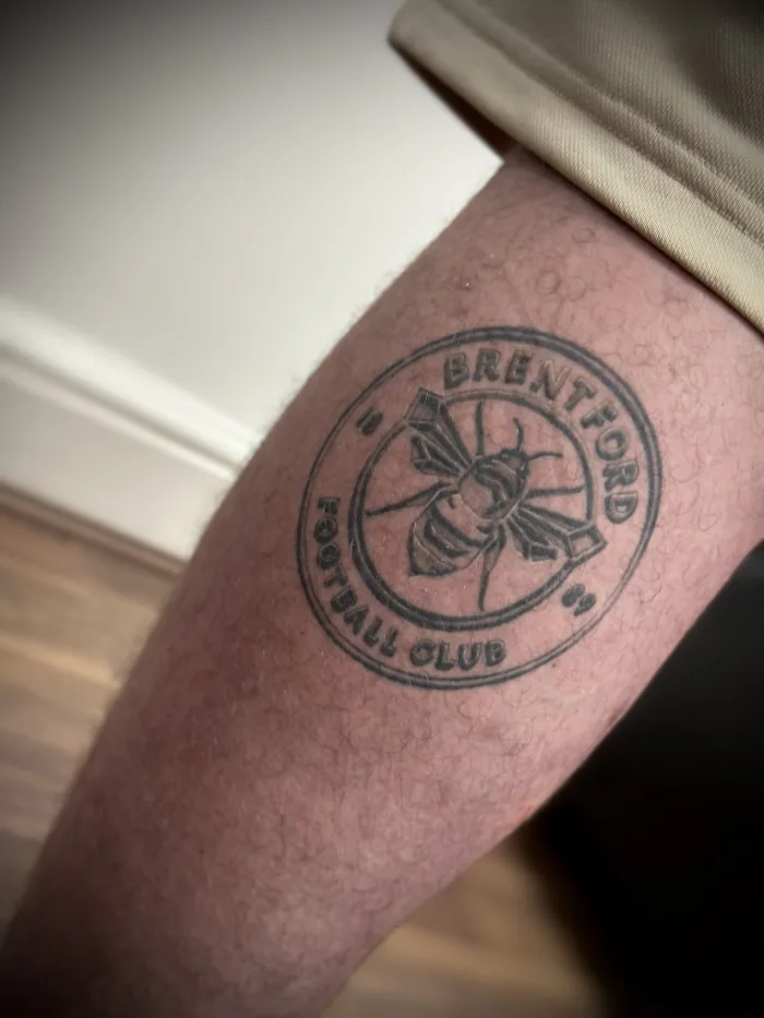 Fully healed Brentford Football Club bee tattoo by Esther in Ashford, Surrey